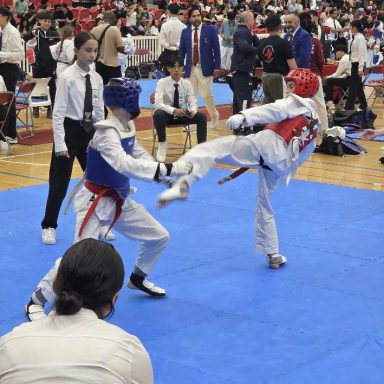20260606_154523 Taekwondo sparring match with a high kick at a tournament