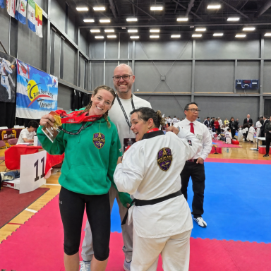 hf_20260616_055531_7aaa311b-e05f-4860-8816-43ec4d2fae86 Rockland Taekwondo athlete celebrating a medal with her coaches at a competition