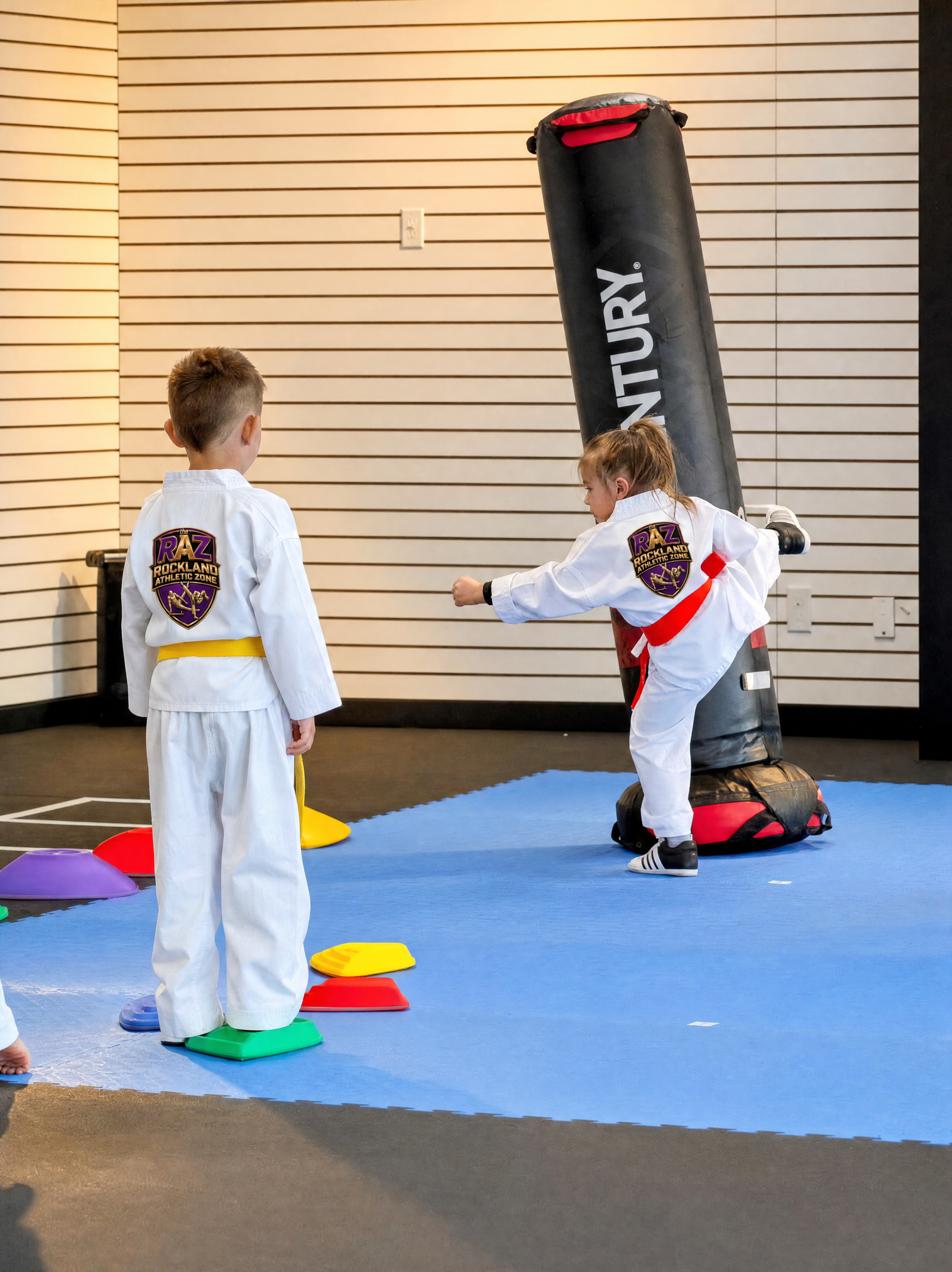 Kids practising strikes on a punching bag during a taekwondo drill