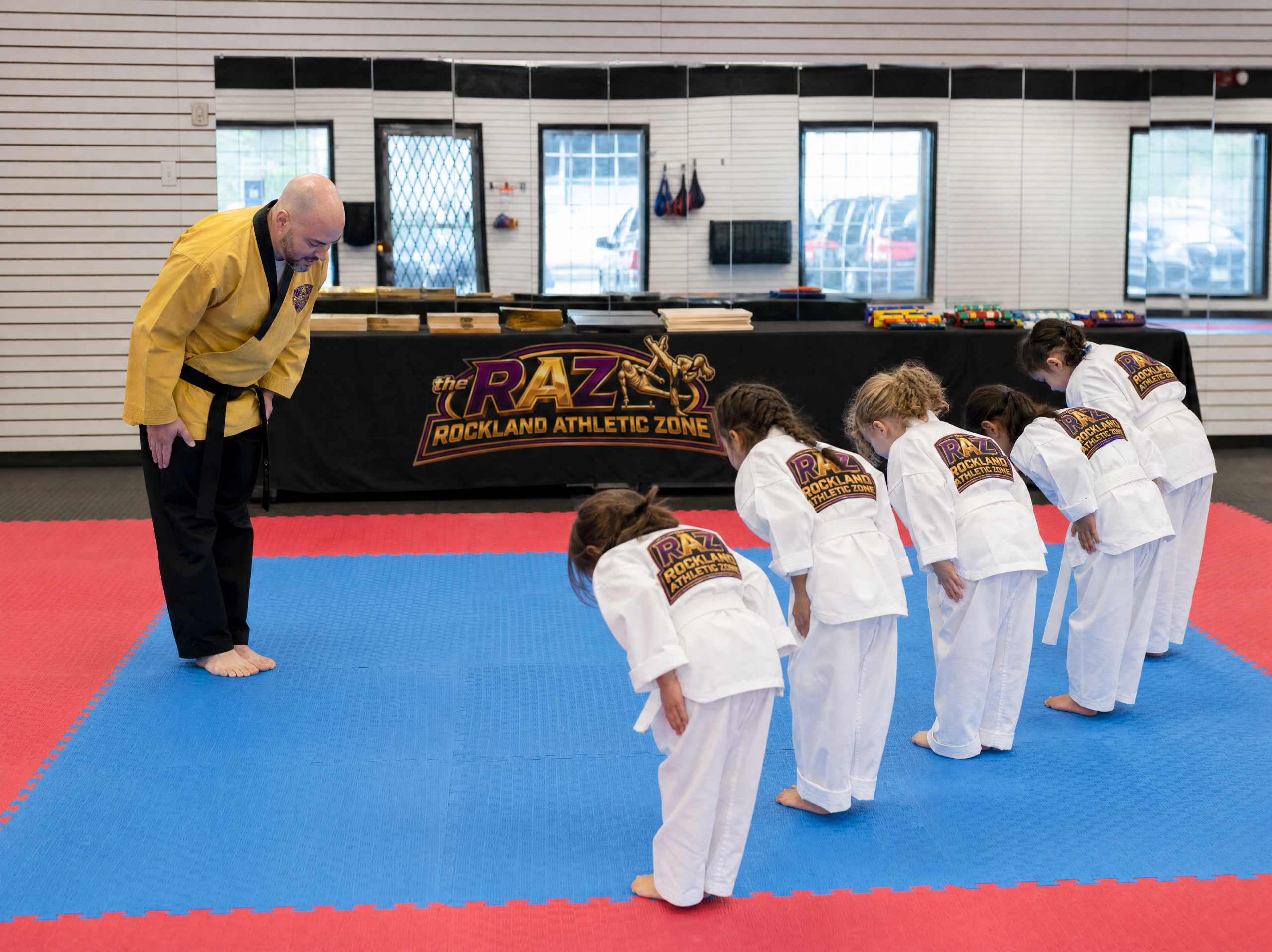Instructor and young students bowing at the start of a taekwondo class