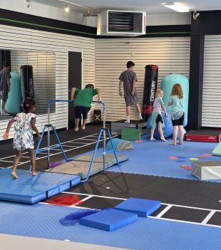 Kids gymnastics class using the training bars and obstacle course at The RAZ