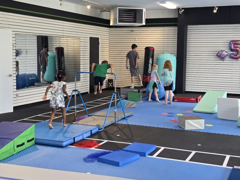 Kids gymnastics class using the training bars and obstacle course at The RAZ