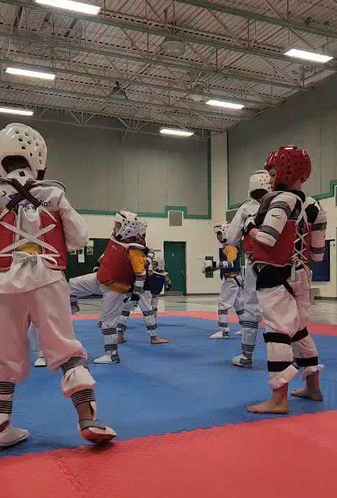 Taekwondo athletes sparring in helmets and chest guards