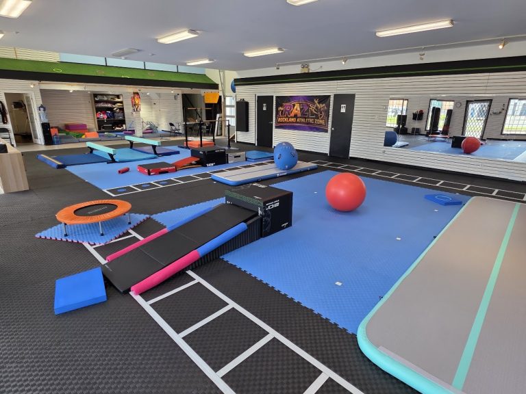 Gymnastics floor at The RAZ set up with balance beams, mats and an exercise ball
